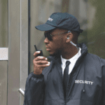 A man in black jacket holding a cell phone.