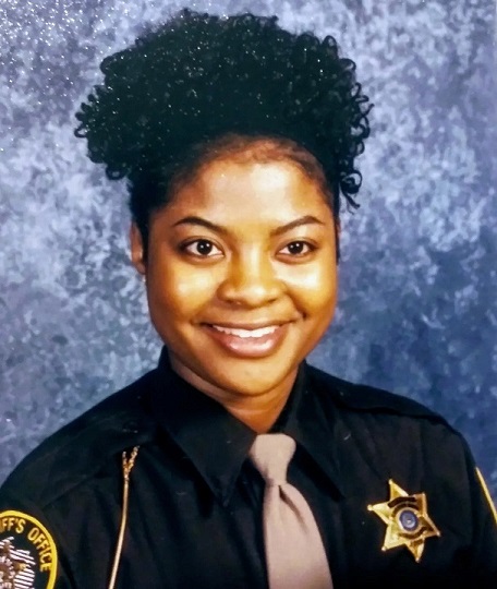 A woman in police uniform smiling for the camera.